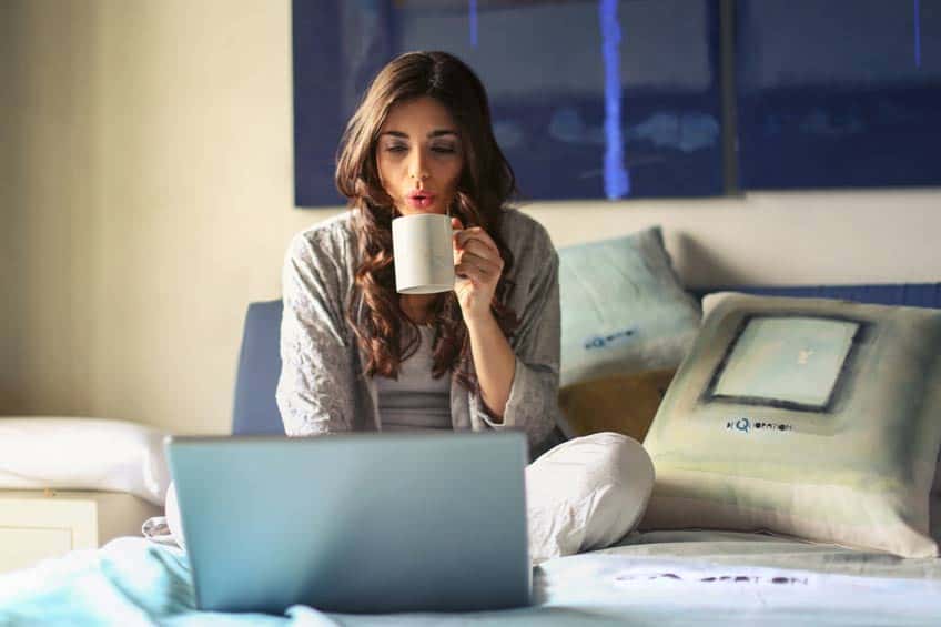 Female student drinking coffee studying for exam in the morning