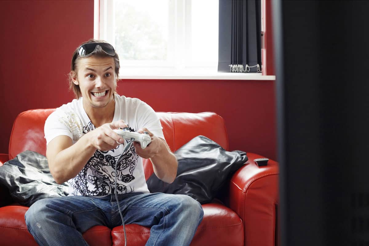 Man sitting on the couch playing video game console