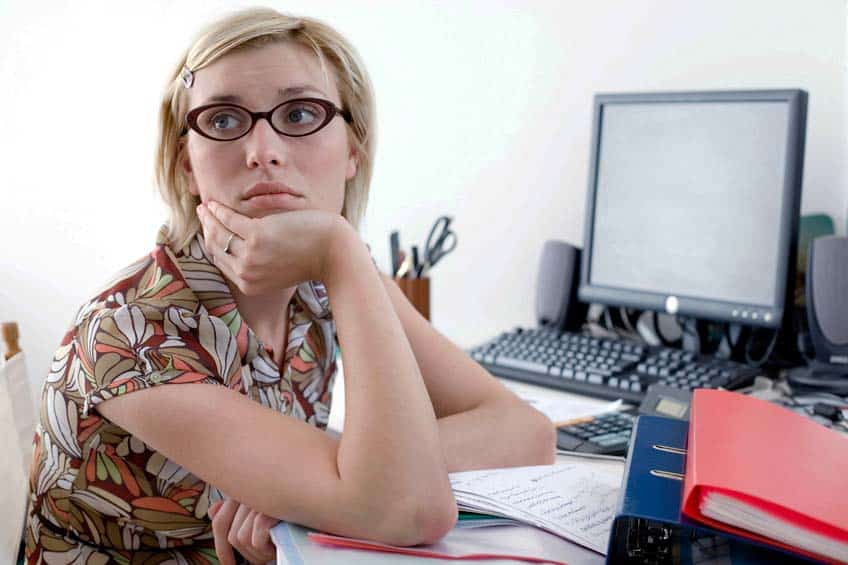 Woman daydreaming at desk in a home office